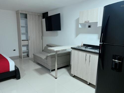 a small kitchen with a table and a refrigerator at APARTA SUITES GRANADA LOF 3 in Cali
