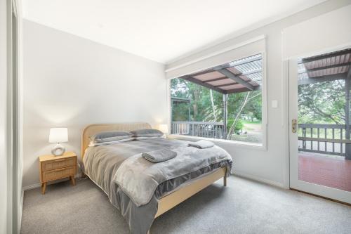1 dormitorio con cama y ventana en Red Rocks Golf & Accommodation - Phillip Island, en Cowes