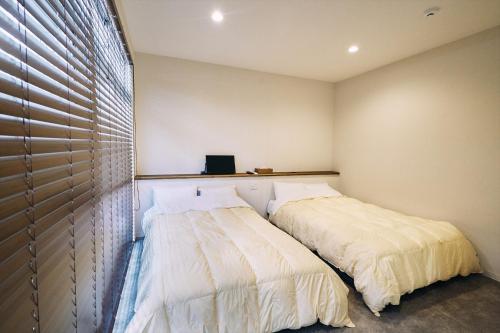 a bedroom with a bed and a window at 「まちのオアシス」STAY UWU 005 空を眺める半露天風呂 in Kochi