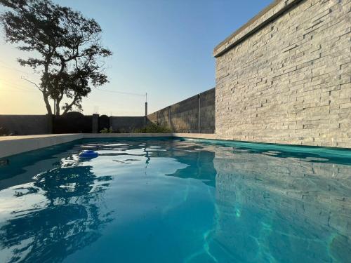una piscina frente a una pared de ladrillo en Casa de las estrellas, en Valles