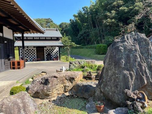 uma grande rocha num jardim ao lado de um edifício em 1日1組限定　和洋折衷 EDOYA em Chiba