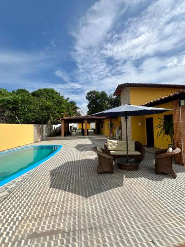 um pátio com uma piscina, uma mesa e um guarda-sol em Espaço Prime SLZ em São Luís