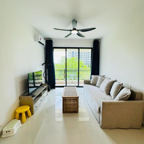 uma sala de estar com um sofá e uma ventoinha de tecto em Forest city Sea view homestay em Gelang Patah