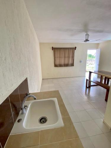 a white sink in a room with a table at Sol y Luna Hospedaje in Valladolid