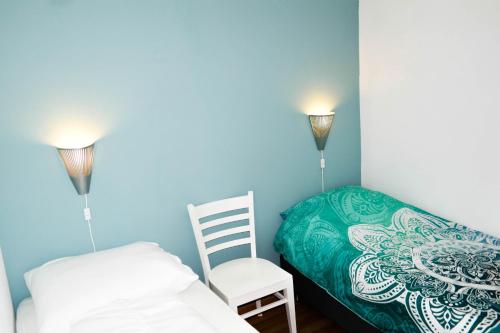 1 dormitorio pequeño con 1 cama y 1 silla en "Heleen" 6 pers, Lauwersmeer waterfront, full equipped and modern, en Anjum