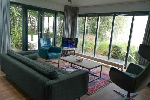 sala de estar con sofá y 2 sillas en "Heleen" 6 pers, Lauwersmeer waterfront, full equipped and modern, en Anjum