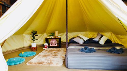um quarto com uma cama numa tenda em หลงฮักเขาแคมป์ปิ้งภูชี้ฟ้า em Ban Huai Khu