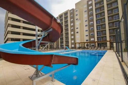 a swimming pool with a slide in front of a building at Apartamento acqua in Pelotas