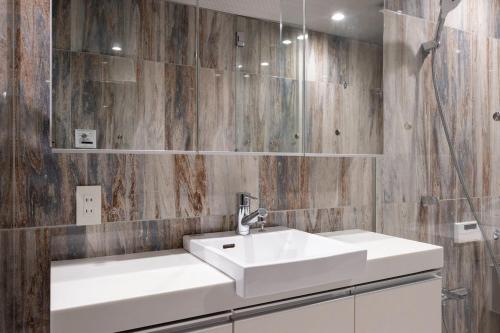 a bathroom with a white sink and a mirror at LEGA LAND Sangenjaya ANNEX in Tokyo