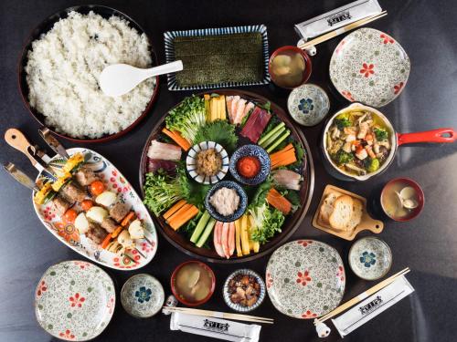 a table with plates of food and bowls of rice at Yufuin Lamp no Yado in Yufu