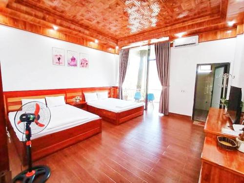 a bedroom with two beds and a desk with a computer at Ruby Tam Đảo in Tam Ðảo