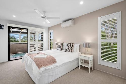 a white bedroom with a bed and a window at 153 Centenary Heights Rd in Yaroomba