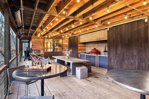 Longhaus: Modern Minimalist Luxury Home: Firepit, outdoor kitchen, pets في Mars Hill: غرفة بها طاولات وكراسي ومطبخ