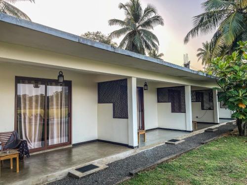 a house with a porch with a table and chairs at Lankapura Heritage in Sigiriya