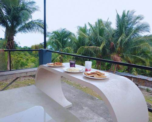 a table with two plates of food and drinks on it at Oslob Hilltop Transient House in Cañang