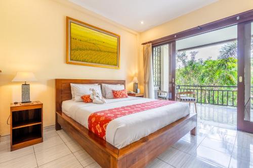 a bedroom with a bed and a balcony at Meruhdani Boutique Hotel Ubud in Ubud