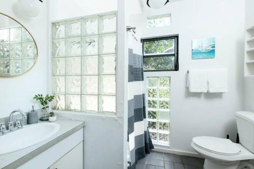 Baño blanco con lavabo y aseo en Sea View & Sunset Haven, en Enighed
