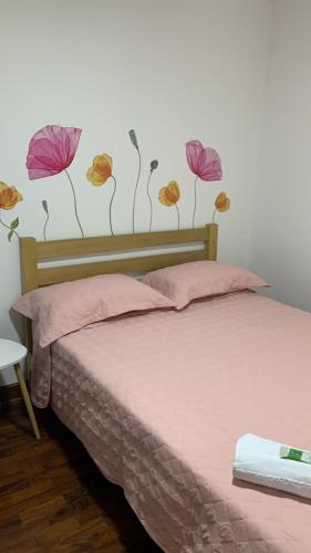 1 dormitorio con 1 cama con flores en la pared en Lindo depa san miguel, 3camas, wifi, terraza., en Lima