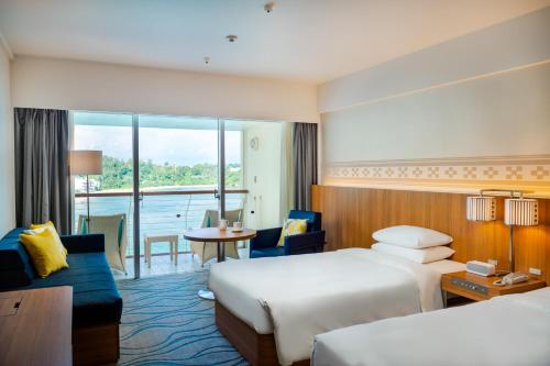 a hotel room with two beds and a balcony at Renaissance Okinawa Resort in Onna