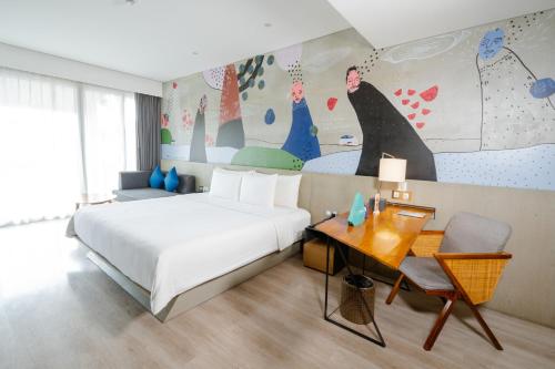 a hotel room with a bed and a table and a desk at ARTOTEL Sanur Bali in Sanur