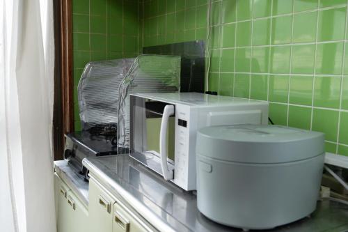 un forno a microonde seduto su un bancone in cucina di 【湯布院の山小屋】サンクラウド・ヒュッテ a Yufu