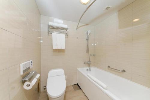 uma casa de banho com um WC, uma banheira e um lavatório. em Renaissance Okinawa Resort em Onna
