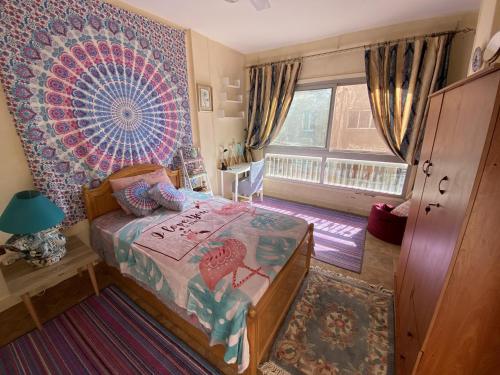 a bedroom with a bed and a large window at Azur 5 Stars Cozy room in Cairo