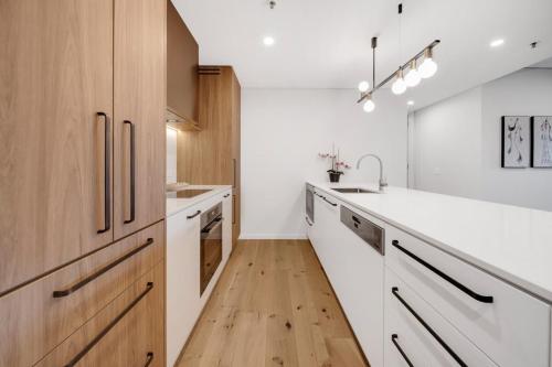 a kitchen with white counters and wooden cabinets at Modern 2-Bed Apartment Near Local Shops in Kingston 