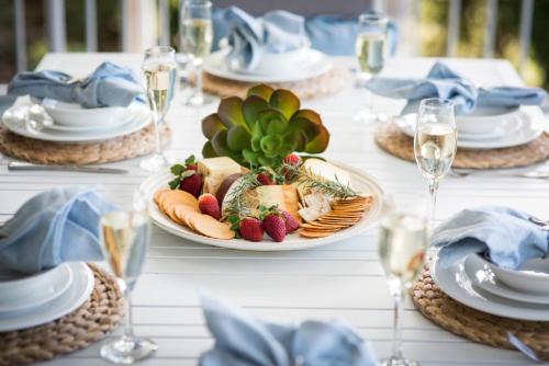 - une table avec des assiettes de nourriture et des verres de vin dans l'établissement Coastal Charm On Airlie, à Airlie Beach