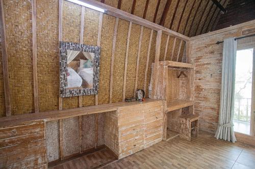 Cette chambre comprend un miroir et un mur en bois. dans l'établissement Desa Sweet Cottages, à Nusa Lembongan
