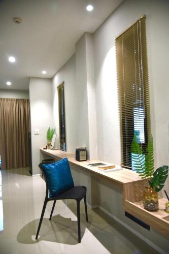 a blue chair sitting at a desk in a room at HAKKA Wellness Residence in Samut Songkhram