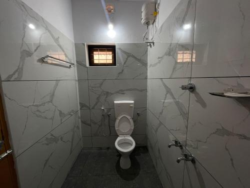 a bathroom with a toilet and a shower stall at Greenview Royal Stay Near Amrita Hospital Edappally in Cochin