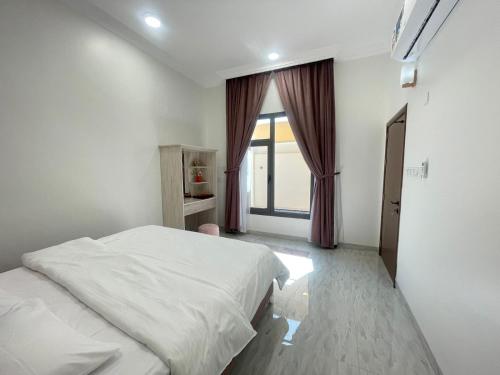 a bedroom with a white bed and a window at AL Rabie Villa, Nizwa Grand Mall in Firq
