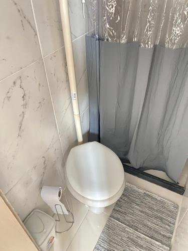 uma pequena casa de banho com um WC e um rolo de papel higiénico em Suite Brava em Búzios