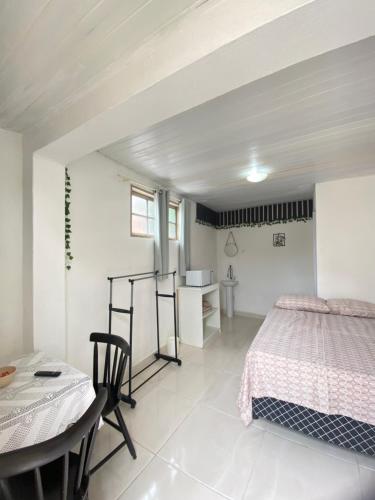 Dormitorio blanco con cama y mesa en Suite Brava, en Búzios