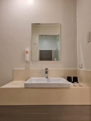 a bathroom with a sink and a mirror at Go Hotels Otis - Manila in Manila