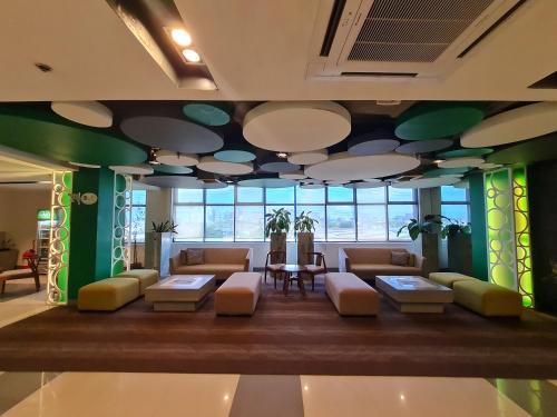 a lobby with couches and tables in a building at Go Hotels Otis - Manila in Manila