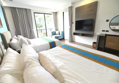 Habitación de hotel con 2 camas y TV de pantalla plana. en Magarra Hotel en Orani