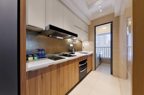 a kitchen with a sink and a stove at East Maple International Apartment - Guangzhou International Financial City Keyun Road Metro Station in Guangzhou