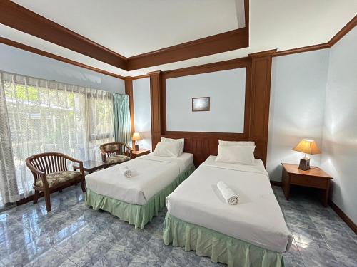 ein Hotelzimmer mit 2 Betten und einem Fenster in der Unterkunft Sea View Resort Rayong in Rayong