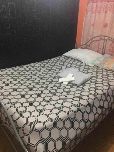 1 cama con edredón blanco y negro en Marcella Realty Apartment, en Calasiao