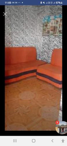 un sofá naranja sentado en una sala de estar en Marcella Realty Apartment, en Calasiao