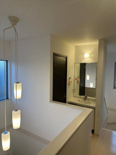 a white bathroom with a sink and a mirror at 清水公園四个房间 in Noda