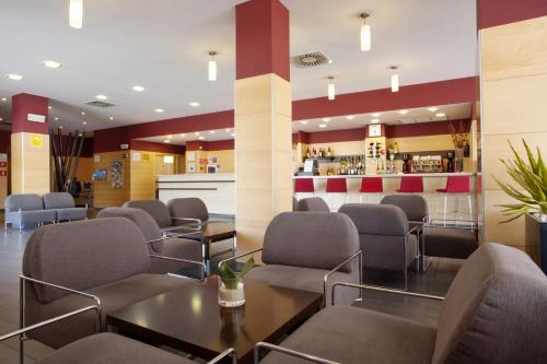 a living room filled with tables and chairs at Holiday Inn Express Málaga Airport, an IHG Hotel in Málaga