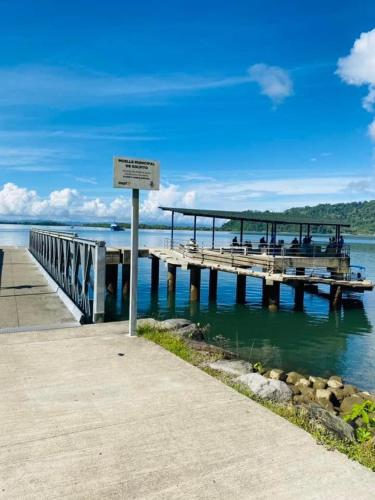a pier with people sitting on it on the water at La Purruja Lodge in Golfito
