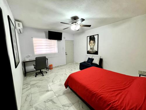 a bedroom with a red bed and a ceiling fan at Cuarto C con cochera cerca del hospital general in Ciudad Victoria