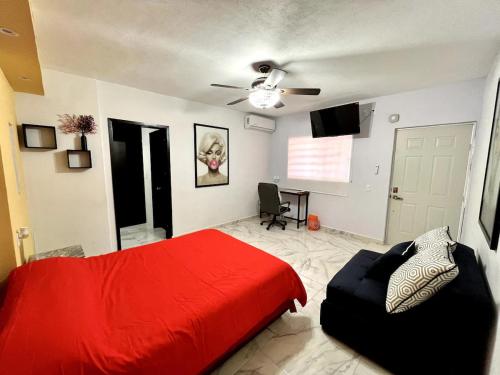 ein Schlafzimmer mit einem roten Bett und einem Sofa in der Unterkunft Cuarto C con cochera cerca del hospital general in Ciudad Victoria