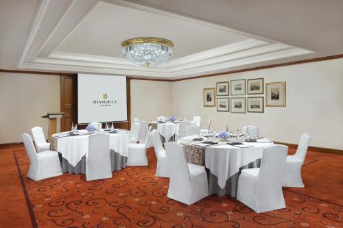 a conference room with white tables and white chairs at Shangri-La Jakarta in Jakarta