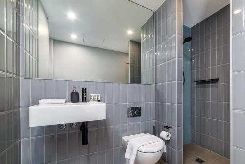 bagno con servizi igienici, lavandino e specchio di Stunning 1BR Apartment with Water Views a Kingston 