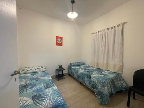 een slaapkamer met 2 bedden en een raam bij Cielos del valle in Salta